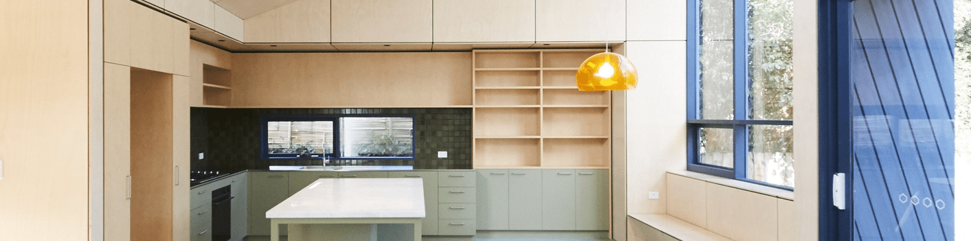 Modern minimalist kitchen with light wood cabinetry, a center island, open shelving, and large blue-framed windows